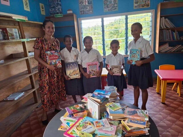 Karen and students of St. Paul's, Naviavia with their new library books.