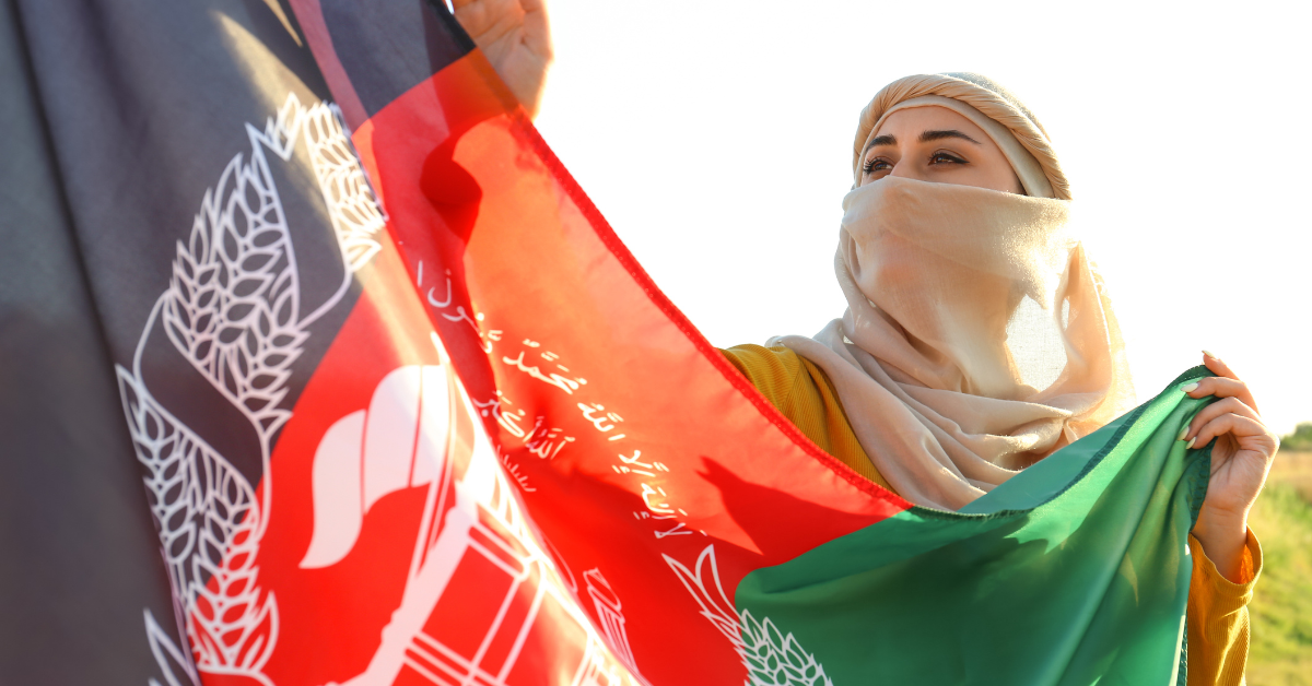 Afghani woman holds up the national flag.